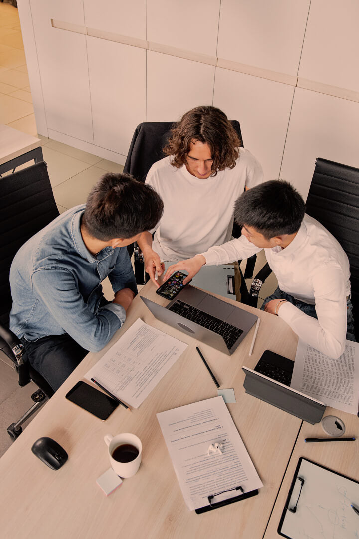 Overhead view of three office workers in a meeting